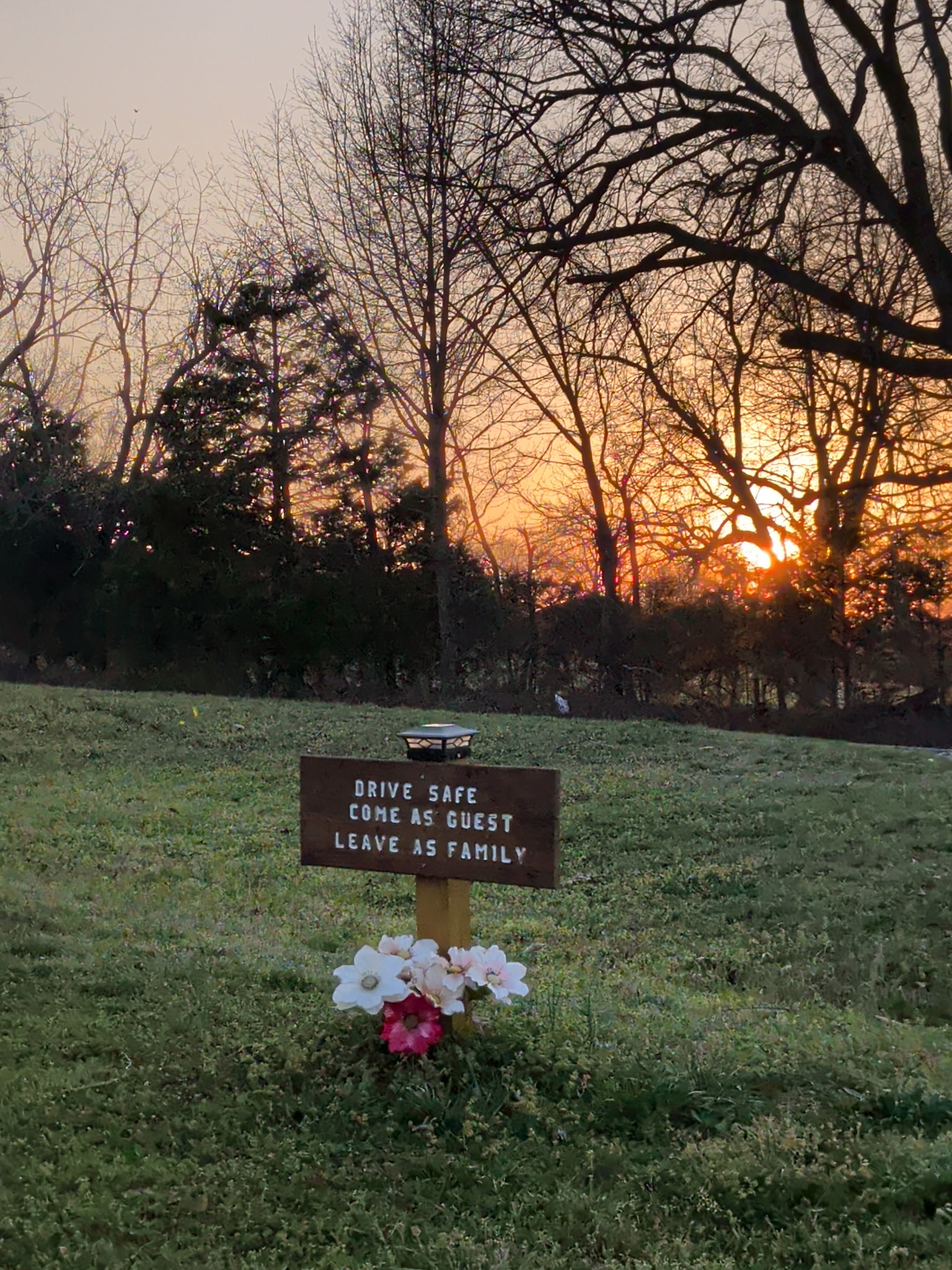 Drive Safe Come as Guest Leave as Family sign at Ozark View RV Park at sunset